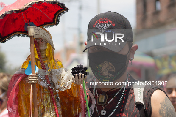 Devotees to the Santa Muerte attend her altar in the Bravo de Tepito neighborhood with face masks because the presence of Covid-19 does not...
