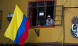 A waiter form a restaurant sees from the window alongside Colombian Flag the at el Chorro...