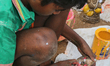 Tamil boy painting small clay idols of Lord Ganesha (Lord Ganesh) at an idol workshop alon...