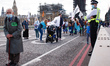 An elderly member of climate change activist movement Extinction Rebellion takes part in a...
