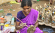 Tamil woman painting small clay idols of Lord Ganesha (Lord Ganesh) at an idol workshop al...