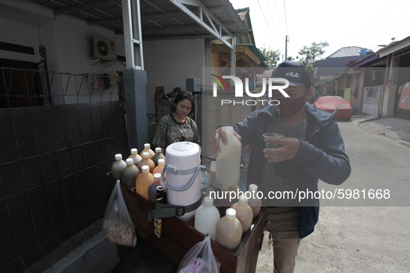 A seller herbal medicine wearing a face mask serves customers in Bogor, West Java, on September 8, 2020. During the pandemic, herbal drinks...
