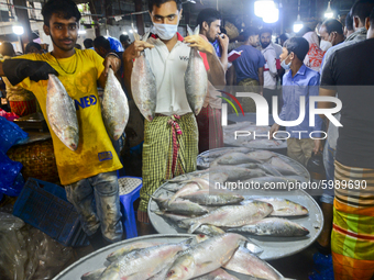 Bangladeshi vendors show Hilsa fish for sell at the Karwan Bazar wholesale fish market in Dhaka, Bangladesh, on September 10, 2020. (