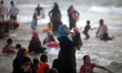 Palestinians are seen at the beach as the sun sets during a summer's day in Gaza City, on...