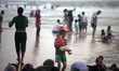 Palestinians are seen at the beach as the sun sets during a summer's day in Gaza City, on...