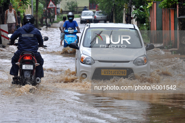 Commuters wade through a water logged street following heavy rains, in Guwahati, India on September 14, 2020. 