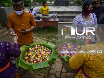 Hindus buy Canang Sari as a complementary material to participate in the ritual of praying Galungan Day at Pura Agung Wana Kerta Jagatnatha,...