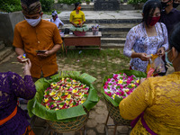Hindus buy Canang Sari as a complementary material to participate in the ritual of praying Galungan Day at Pura Agung Wana Kerta Jagatnatha,...