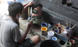A Craftsmen painting a washing place using plastic waste from paint buckets in Padabeungha...