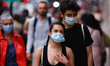 A man and woman wearing face masks walk along Regent Street in London, England, on Septemb...