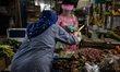 A woman wth full face mask, hand gloves protection when buying groceries at Santa Markat,...