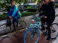 Climate activists and students are seen crossing the Rijksmuseum with their bikes at the Museumplein during the Global Climate Strike, in Am...