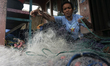 A woman is repairing her husband's fishing nets, who works as a fisherman in Sungsang, Ban...