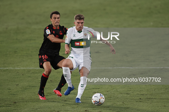 Raul Guti of Elche and Ander Guevara of Real Sociedad compete for the ball during the La Liga Santader match between Elche CF and Real Socie...