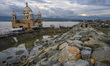 Residents enjoy the view near the floating mosque which collapsed into the sea after being...