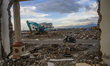 A motorbike rider passes in front of the ruins of a house that was destroyed by the tsunam...