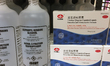Bottles of isopropyl alcohol beside boxes containing Lianhua Qingwen capsules (used to rem...