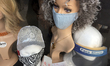 Mannequin wearing a face shield and surgical face mask in the window of a salon during the...