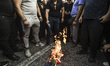 Armenians who live in Greece, burn a flag of Azerbaijan during a rally in Athens, Wednesda...