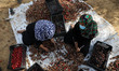 Palestinians sort red dates in baskets during the yearly harvest in Deir al-Balah in the c...