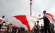 People hold the large historical white-red-white flag of Belarus during a rally of solidar...