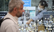 An Iranian trader wearing a protective face mask adjusts his shop window in a bazaar in no...