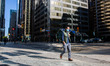 A person walks through a largely empty University and King intersection in downtown Toront...