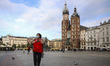 A woman is wearing a protective face mask while walking through the Main Square during cor...