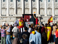 Demonstrators uploaded to an advertising poster to see the passage of the parade where "Covid Exit Madrid" can be read in front of the Royal...