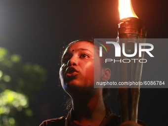 A female activist holds torch during a torch-lit protest demanding women's safety and justice for rape victims in Dhaka, Bangladesh, October...