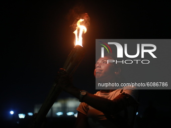 A female activist holds torch during a torch-lit protest demanding women's safety and justice for rape victims in Dhaka, Bangladesh, October...