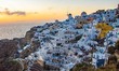 Magic hour in the dusk just after the sunset in the famous Oia Village with blue dome chur...