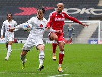 Milton Keynes Dons George Williams is challenged by Gillingham's Jordan Graham during the first half of the Sky Bet League One match between...