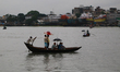 People cross over the Buriganga River on a rainy day in Dhaka on October 22, 2020. 