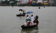 People cross over the Buriganga River on a rainy day in Dhaka on October 22, 2020. 