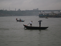 People cross over the Buriganga River by small wooden boats on a rainy day in Dhaka, Bangladesh on October 23, 2020.  Rainfall occurs in var...