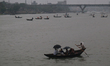 People cross over the Buriganga River by small wooden boats on a rainy day in Dhaka, Bangl...