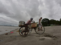 A fish vendor returned  home  after  cleans his bicycle and basket as dark clouds gather in the sky, in Guwahati, India on 24 October 2020....