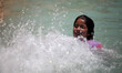 A Palestinian girl plays in a fountain basin to cool off during hot weather in Gaza City M...
