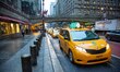 Iconic yellow taxi stationary inline queued and moving on the streets of Midtown Manhattan...