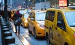 Iconic yellow taxi stationary inline queued and moving on the streets of Midtown Manhattan...