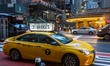 Iconic yellow taxi stationary inline queued and moving on the streets of Midtown Manhattan...