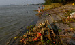 Melted structure of an idol along with other debris rests at a river bank in Kolkata after...
