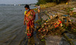 A lady makes her way amidst the debris that rest at a river bank in Kolkata after immersio...