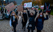 A group of women are arriving tot the place of the protest while holding placards, against...