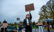 A woman is rising up a placard, during the protest against the abortion ban In Poland, tha...