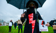 A woman is holding a flyer and wearing the thunder red symbol in solidarity with Polish wo...