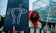 A woman is holding a placard with an uterus drawn on it, in solidarity with Polish women,...