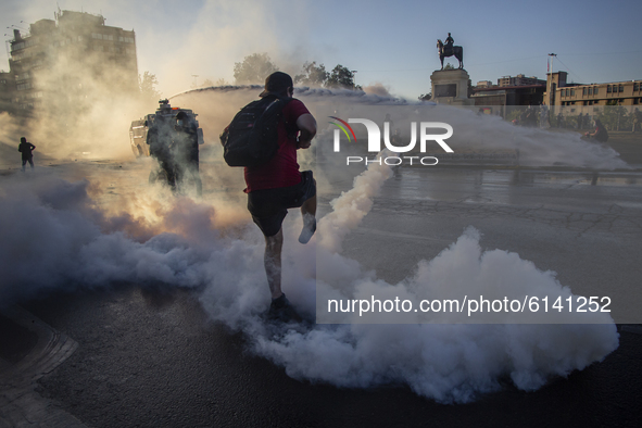 A person kicks a tear bomb dropped by riot police of carabineros de Chile (COP) on October 30, 2020 in Santiago de Chile, Chile. 
Amid of t...