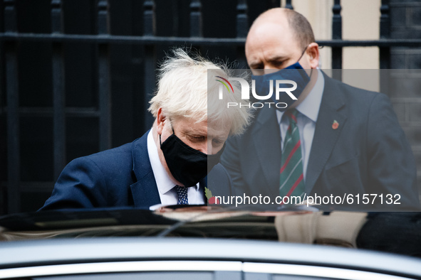 British Prime Minister Boris Johnson wears a face mask and remembrance poppy as he leaves 10 Downing Street heading for his weekly Prime Min...